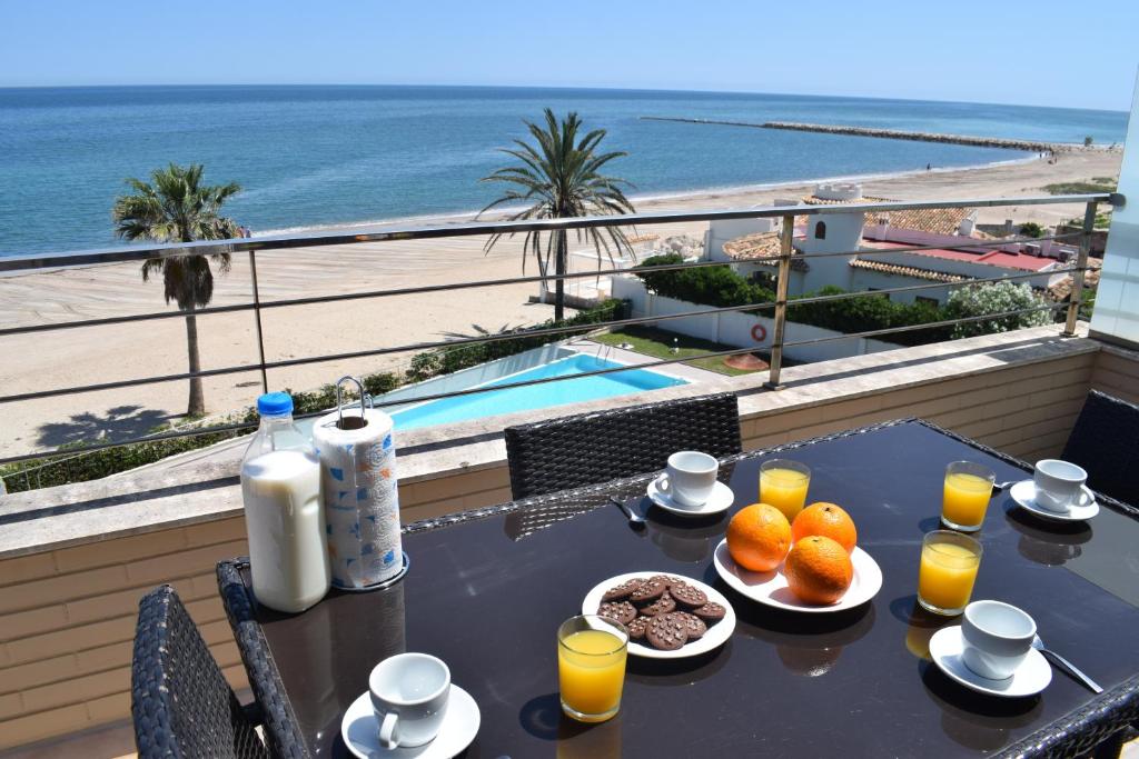 - une table avec de la nourriture et une vue sur la plage dans l'établissement Anacasa Atico Riu Bolulla Marenia AT1101, à Dénia