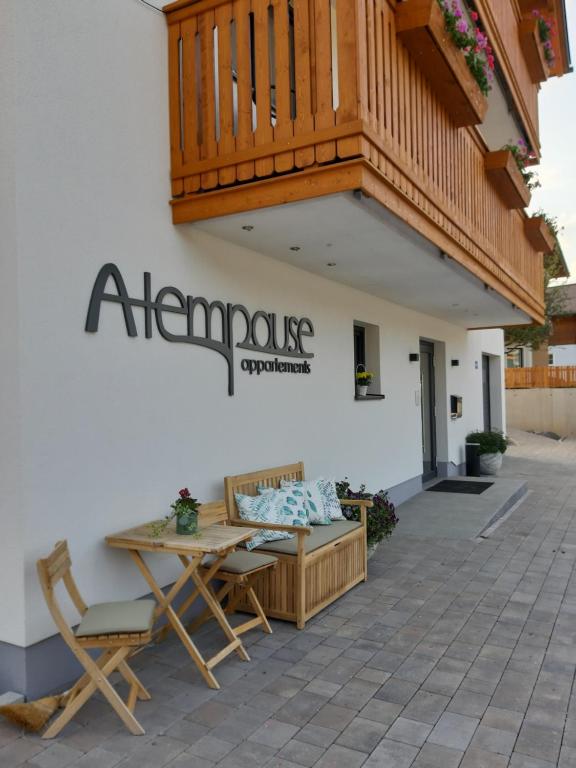 Die Atempause - appartements في فلاخاو: علامة على جانب مبنى مع طاولة وكراسي