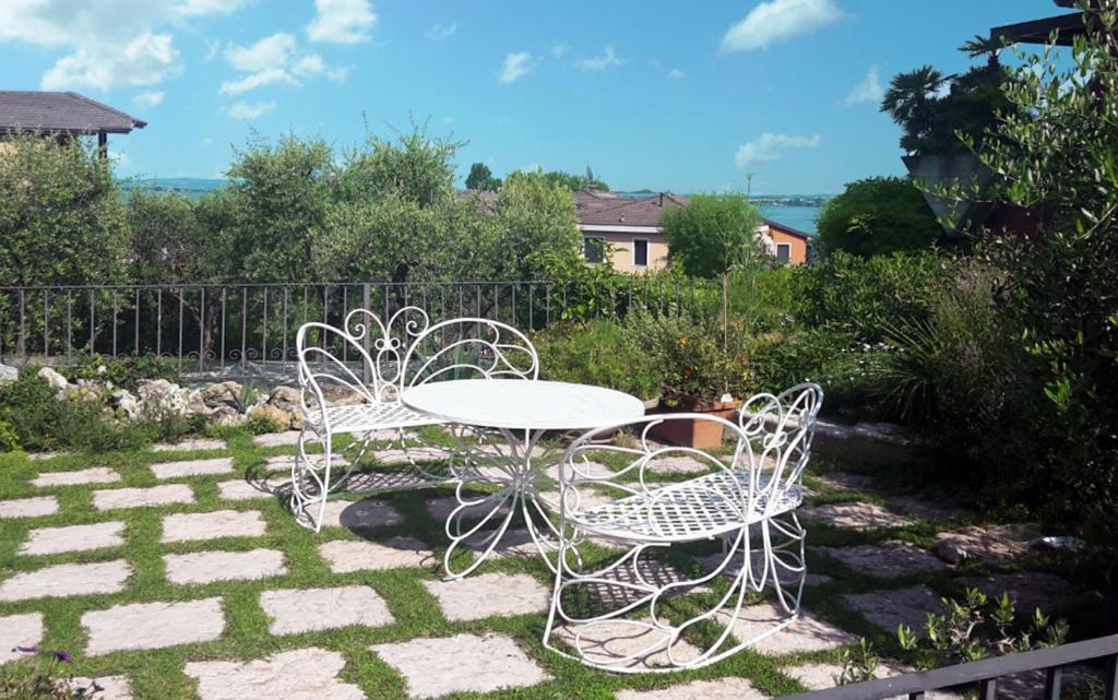 einen weißen Tisch und Stühle im Garten in der Unterkunft white holiday house in Desenzano del Garda
