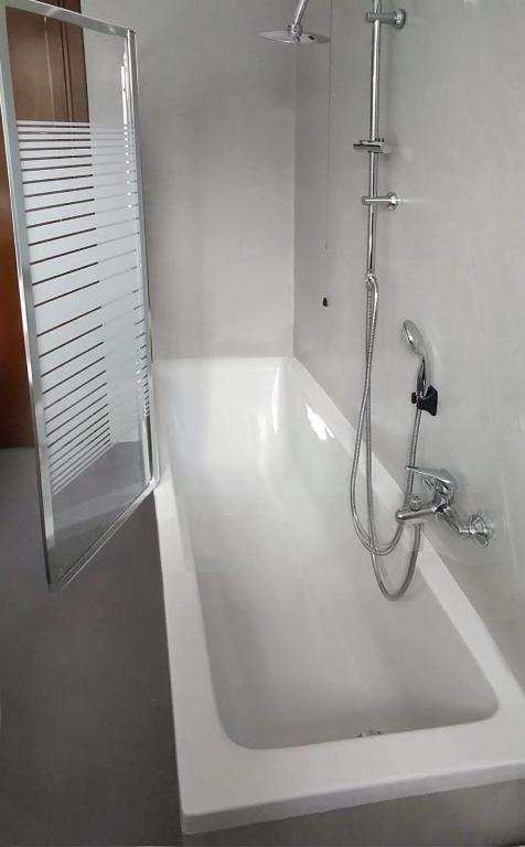 biała łazienka z prysznicem i wanną w obiekcie Giuliana's House w mieście Desenzano del Garda