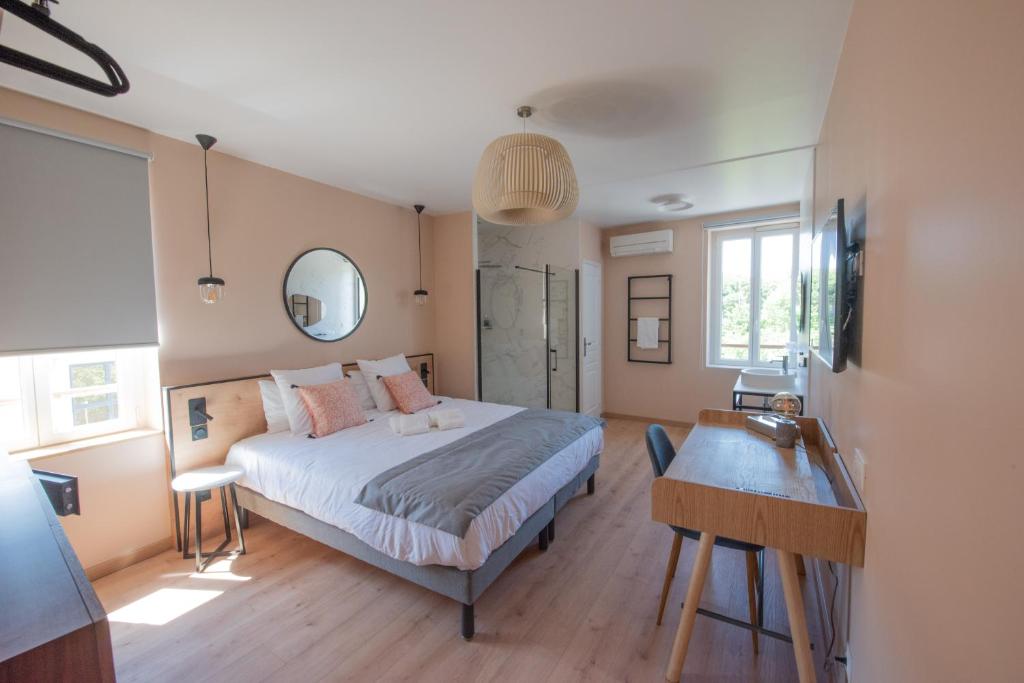 een slaapkamer met een bed en een bureau erin bij Hotel Restaurant La Villa Arena in Carry-le-Rouet