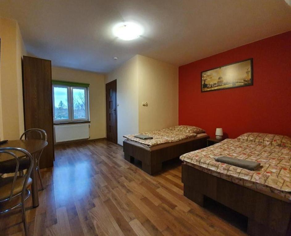 Cette chambre comprend 2 lits et une table. dans l'établissement Albinos, à Albigowa