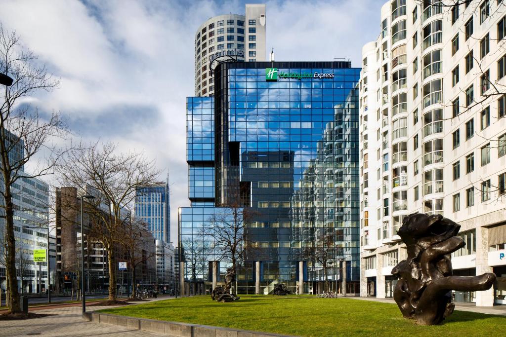 eine Skulptur in einem Park vor hohen Gebäuden in der Unterkunft Holiday Inn Express Rotterdam - Central Station, an IHG Hotel in Rotterdam