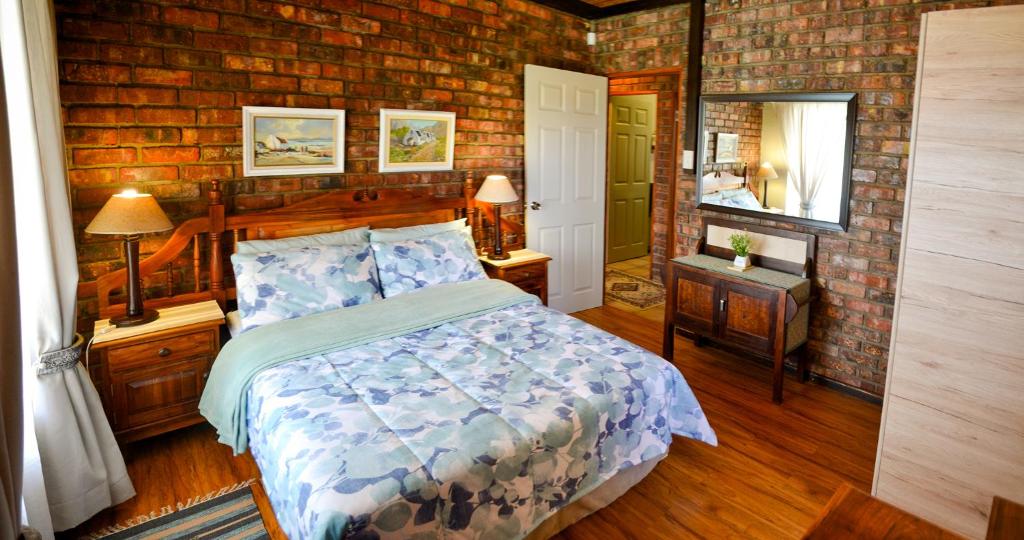 um quarto com uma cama e uma parede de tijolos em Palm Cottage - Colchester - 5km from Elephant Park em Colchester