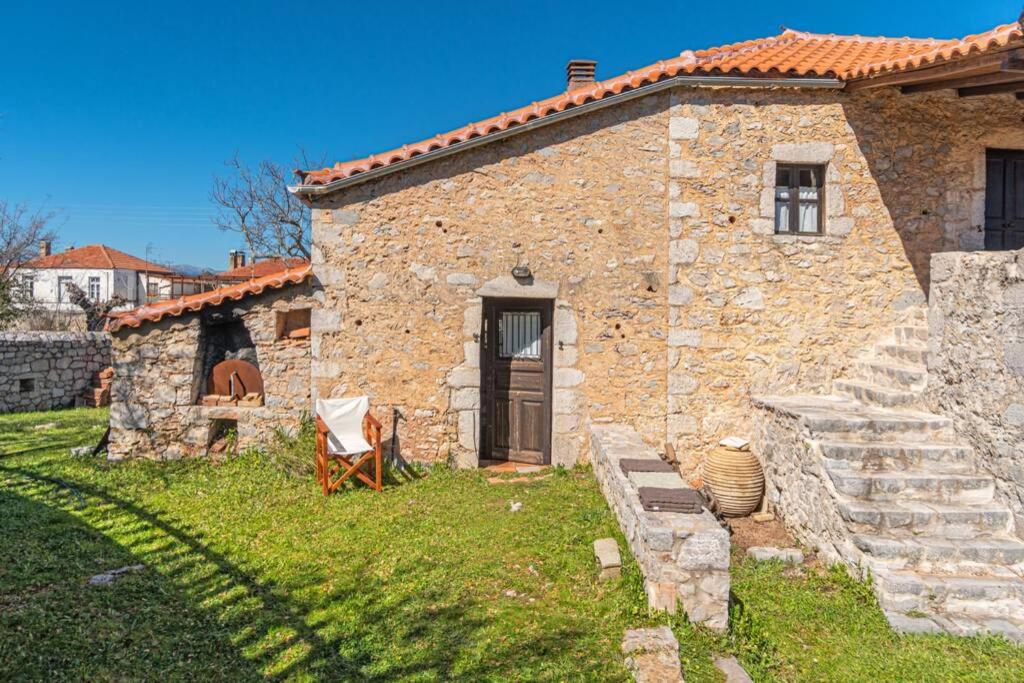 een stenen huis met een deur en een tuin bij MYRTILO TRADITIONAL STONE HOUSE !!! in Peletá