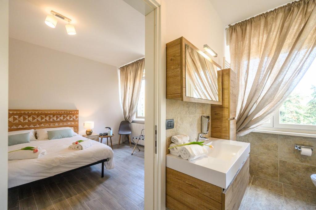 een slaapkamer met een bed en een badkamer met een wastafel bij Casa Porta Nuova Verona in Verona