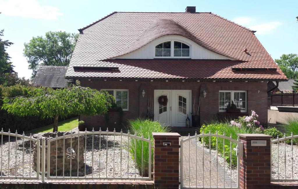 ein Haus mit einem weißen Zaun davor in der Unterkunft Spreewald-Ferienwohnung Jahn in Radensdorf