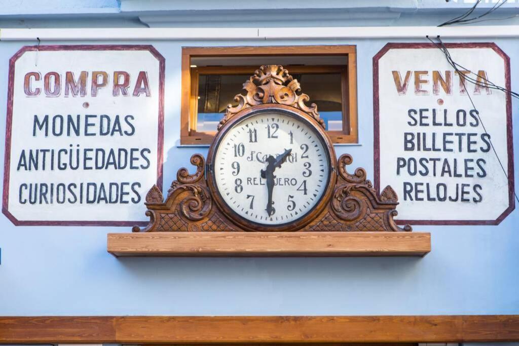 un orologio sul lato di un edificio con cartelli di Finca Reloj a Valencia