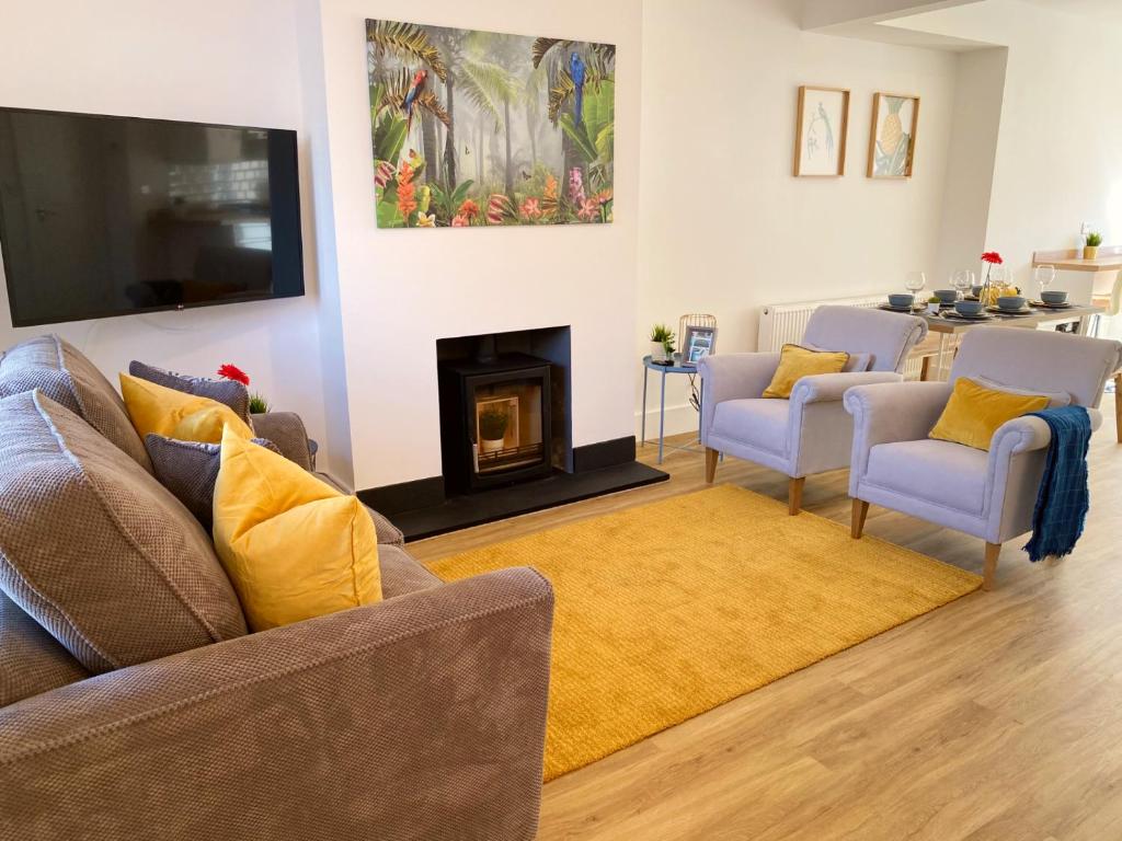 a living room with two couches and a fireplace at Stunning New House - Great Location - Garden - Parking - Fast WiFi - Smart TV - Beautiful 2 Bedroom House sleeps up to 6! Only 5 min drive to Sandbanks beach! in Parkstone