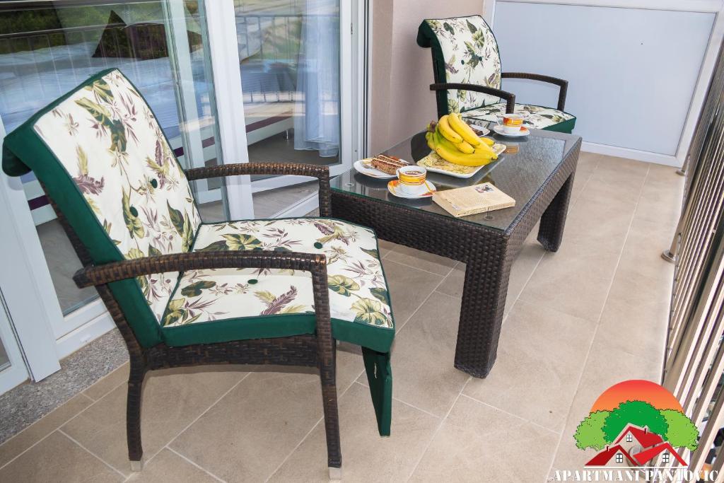 two chairs and a table with a table with bananas on it at Apartmani Pantovic - Apartman 1 in Trebinje