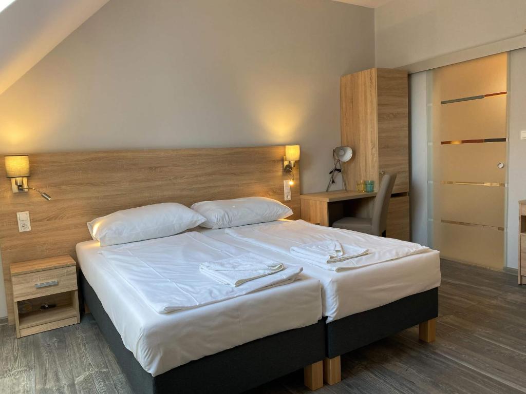 1 dormitorio con 1 cama grande y cabecero de madera en Kis Szieszta panzió, en Balatonboglár
