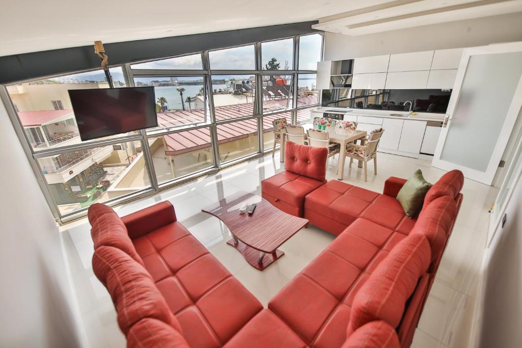 vista sul soffitto di un soggiorno con divano rosso di Yaraşır Family Suite a Didim