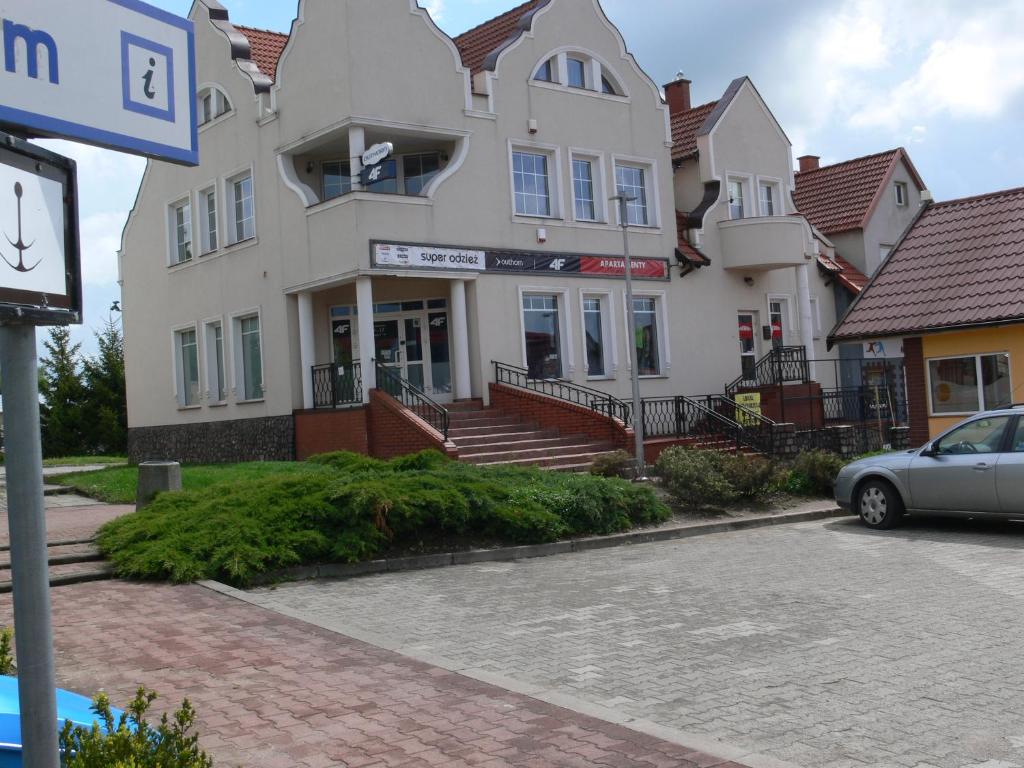 een gebouw waar een auto voor geparkeerd staat bij Apartament w Węgorzewie in Węgorzewo
