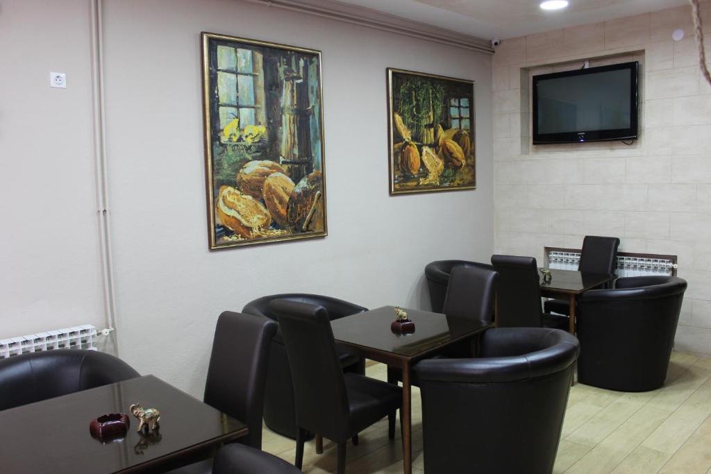 a waiting room with tables and chairs and a tv at Hotel San in Trebinje