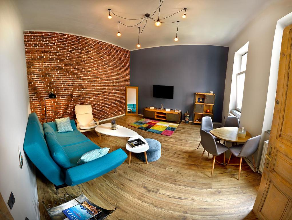 a living room with a blue couch and a brick wall at Maniu Home in Cluj-Napoca