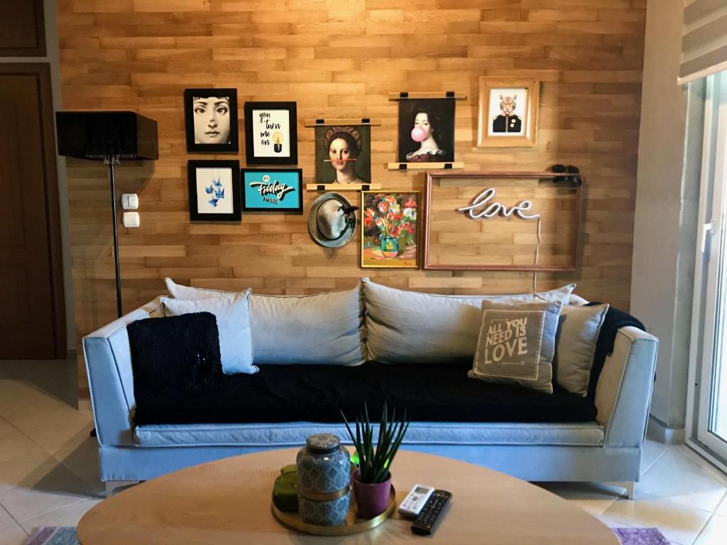 a living room with a couch and pictures on the wall at C&C Apartments in Alexandroupoli