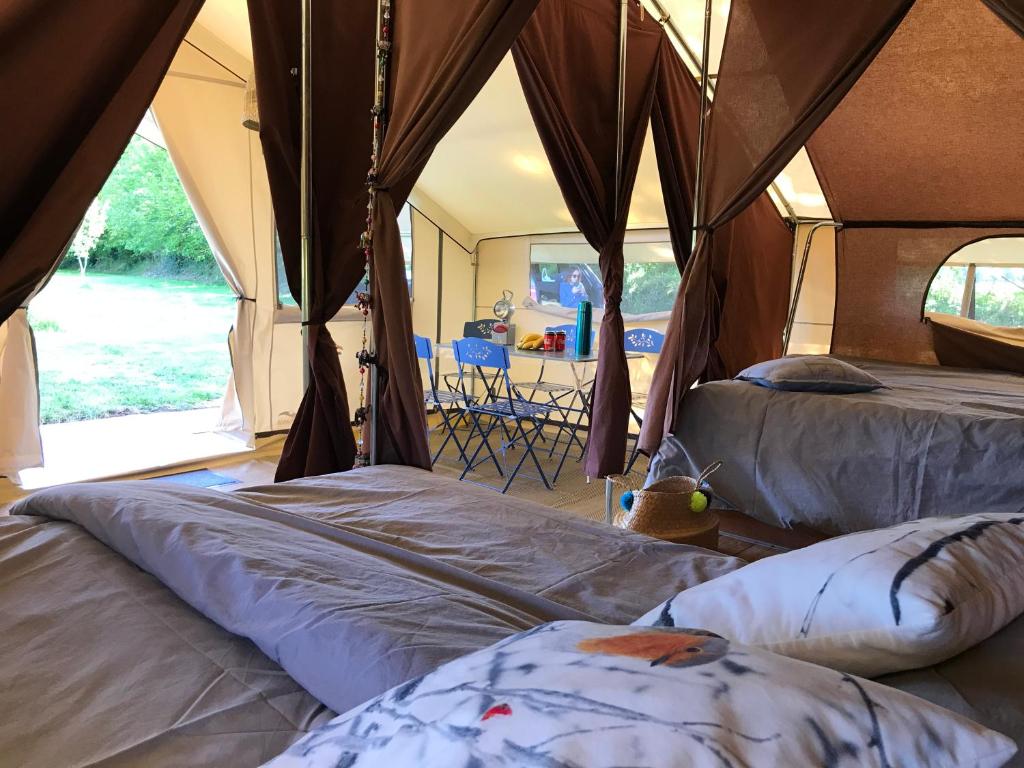 ein Zelt mit 2 Betten und offener Tür in der Unterkunft Tente Lodge les Gîtes de l'Odet in Lanio