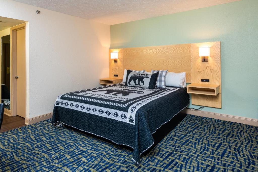 a bedroom with a bed and two lights on the wall at Creekstone Inn in Pigeon Forge