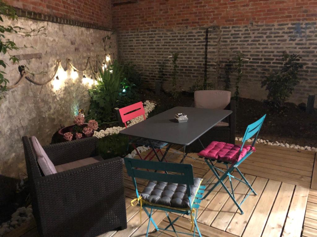 a patio with a table and chairs on a deck at KERWATT loft in Cabourg