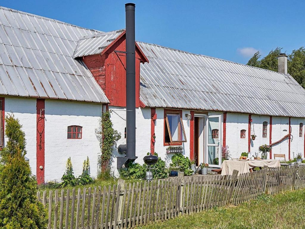 een rood-wit huis met een houten hek bij 6 person holiday home in Nex in Neksø