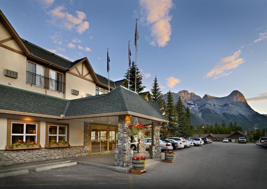 a hotel with a parking lot in front of a mountain at Coast Canmore Hotel & Conference Centre in Canmore