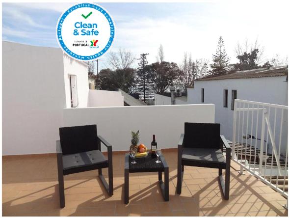 two chairs and a table on a balcony with a sign at Fisherman's Palace in Olhão