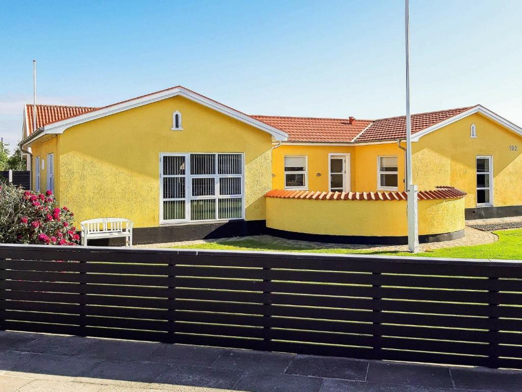 ein gelbes Haus mit einem Zaun davor in der Unterkunft Holiday home Skagen XXX in Skagen