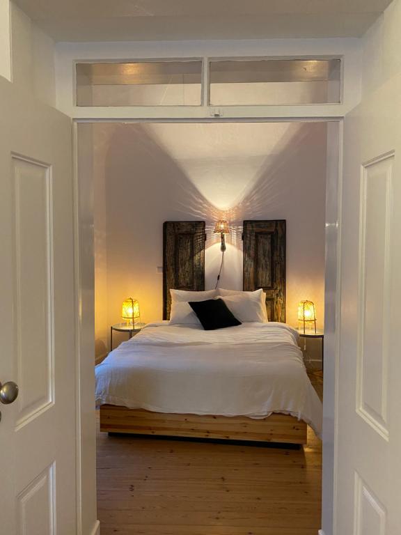 een slaapkamer met een groot wit bed met twee lampen bij Old Town Terrace Apartment in Évora