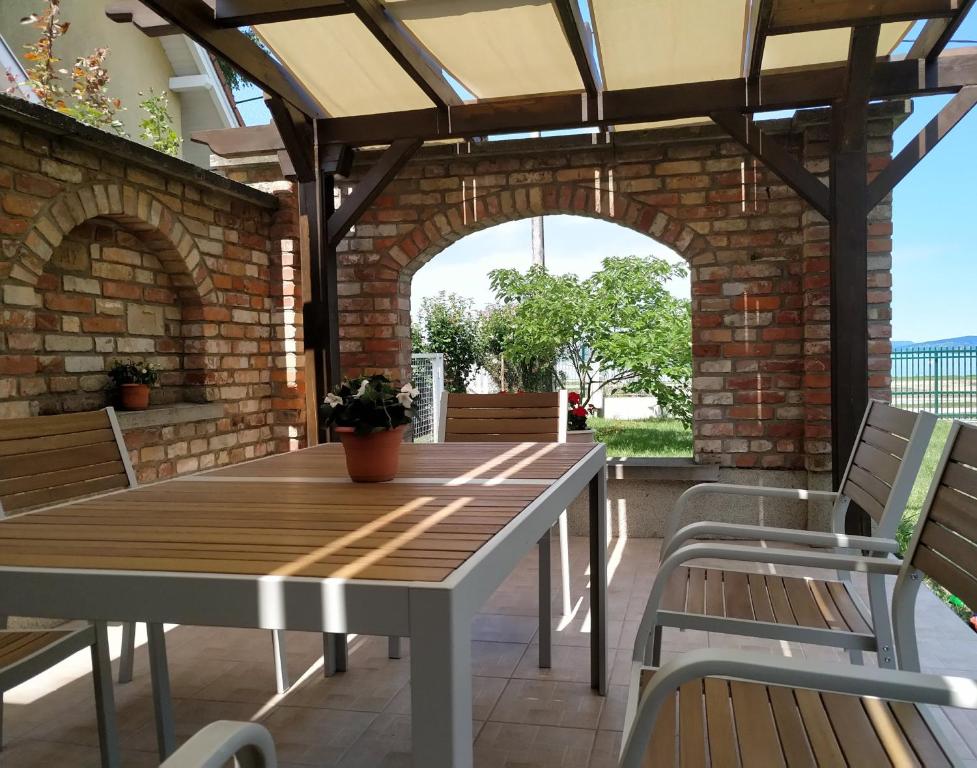 un patio al aire libre con mesa de madera y sillas en Exclusive Beachfront Villa en Fonyód