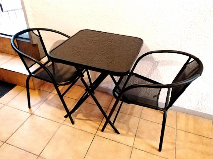 a black table and chair sitting on a tile floor at Appartement T1 quartier château de Pau in Pau