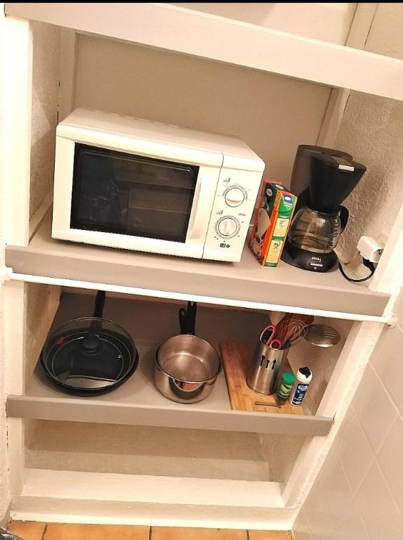 a microwave oven sitting on top of a shelf at Appartement T1 quartier château de Pau in Pau