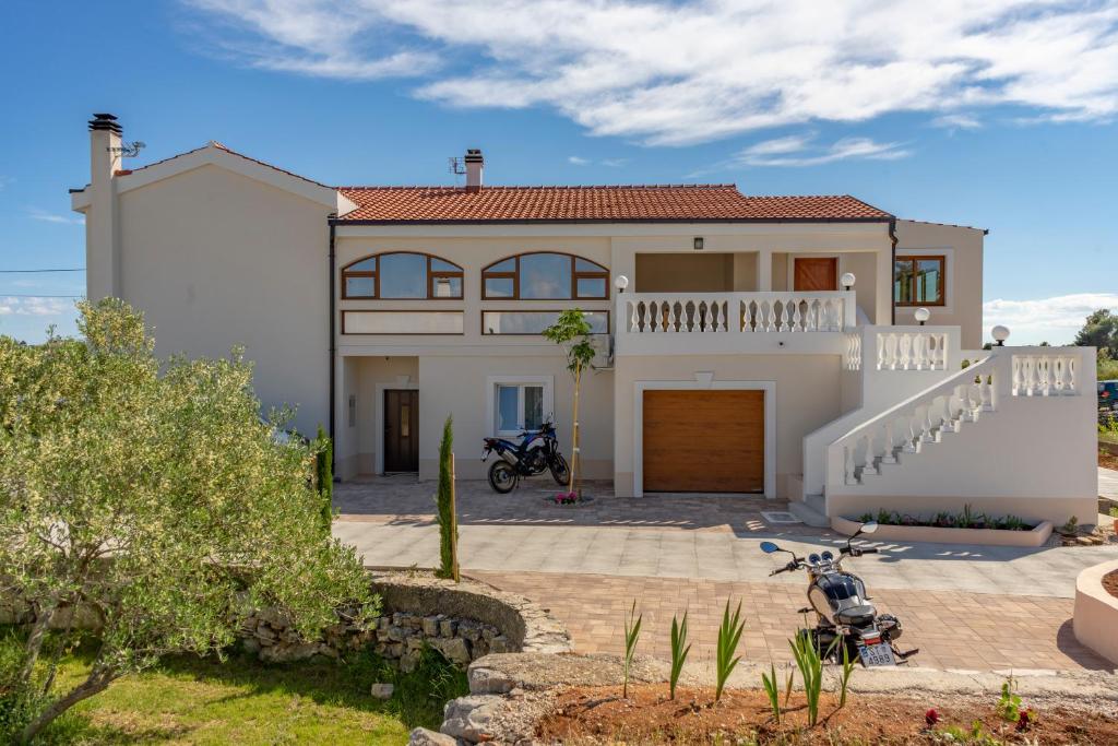 a house with a motorcycle parked in front of it at Villa Jugo (6+2) - New - Mediterranean ambient in Gornje Selo