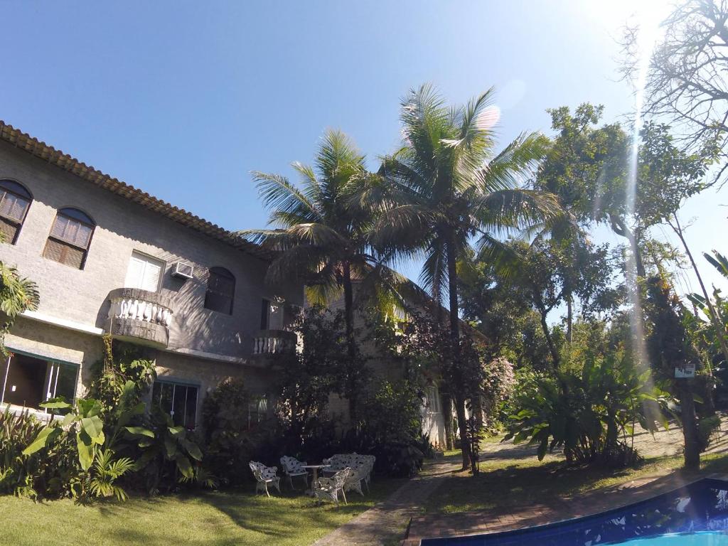 um edifício com palmeiras e uma piscina em Rio Natureza apart 106 no Rio de Janeiro