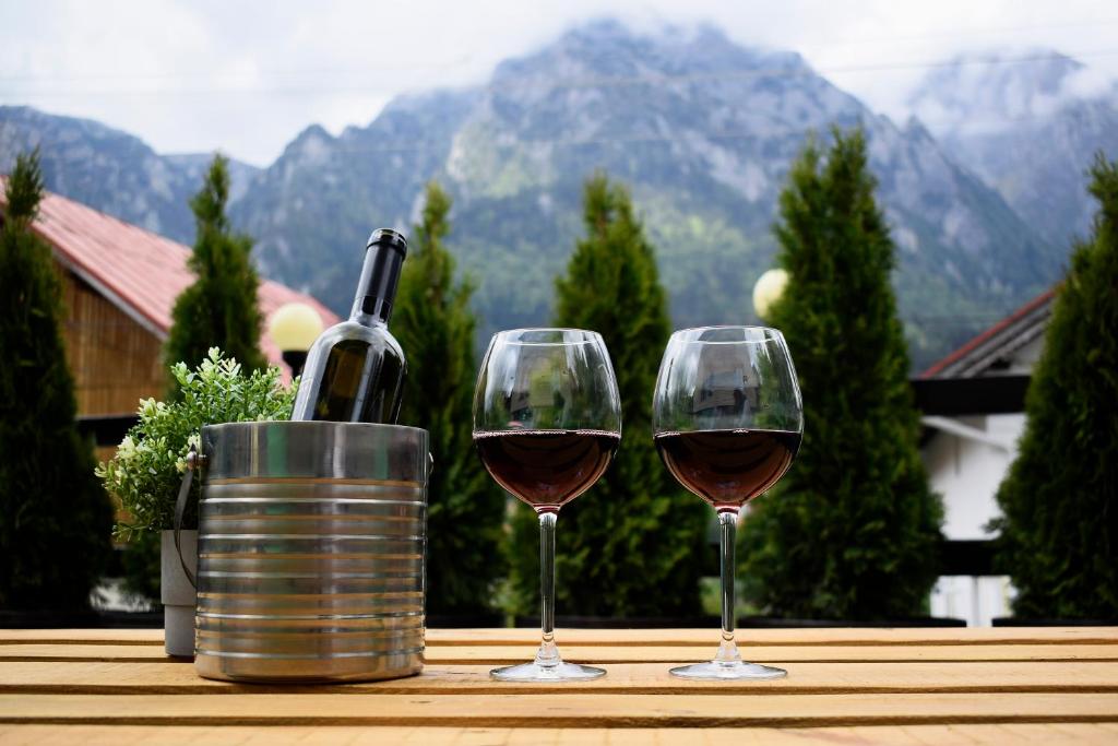 ブシュテニにあるThe Bear Houseのワイン1本とテーブル上のワイン2杯
