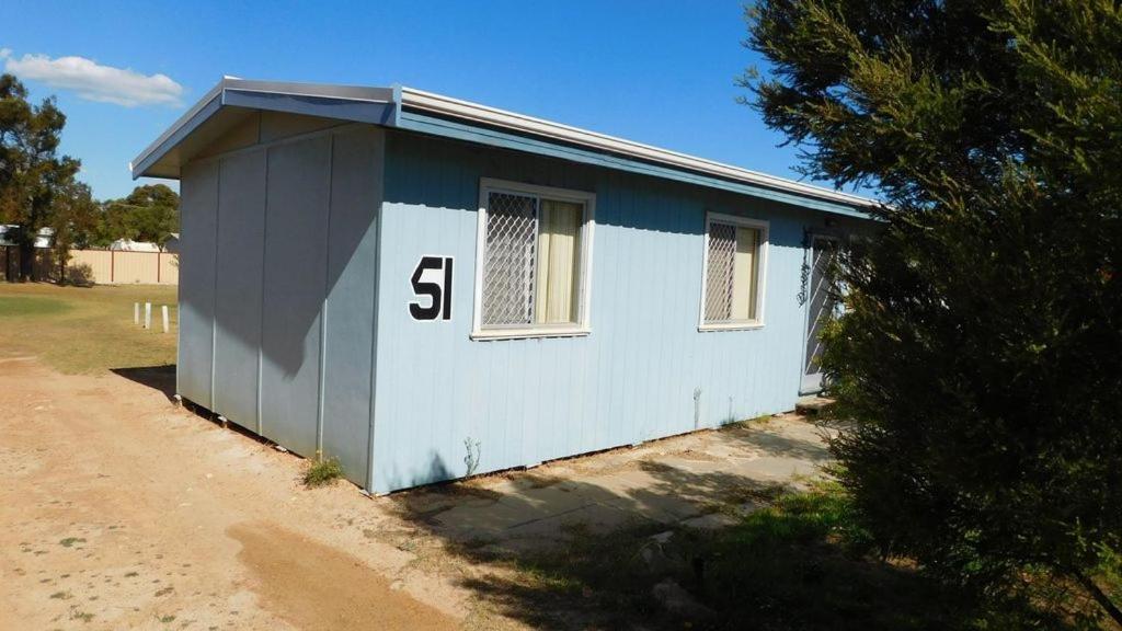 un piccolo edificio blu e bianco con il numero sopra di Cottage 51 - Topspot Cottages a Jurien Bay