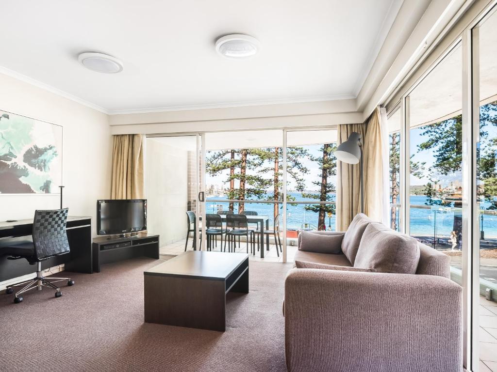 a living room with a couch and a television at Quest Manly in Sydney