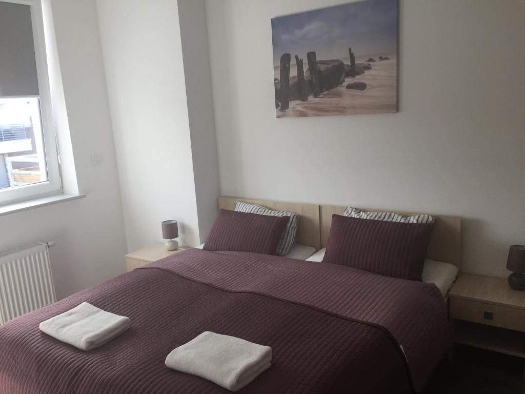 ポゴジェリツァにあるApartament Baltic Parkのベッドルーム1室(ベッド1台、タオル2枚付)