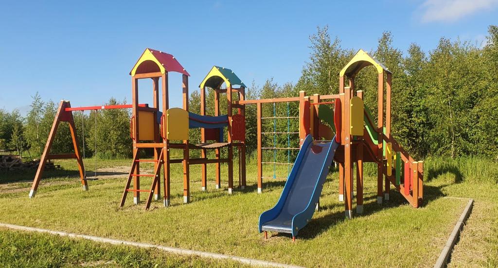 un parque infantil con diferentes tipos de equipos de juego en el césped en Szczere Pole Nad Morzem en Strzezenice