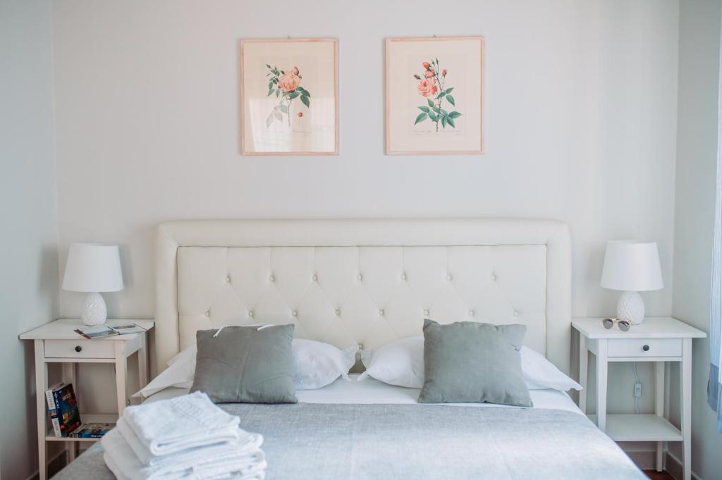 um quarto com uma cama branca com duas mesas de cabeceira em B&B Greco Home em Taormina