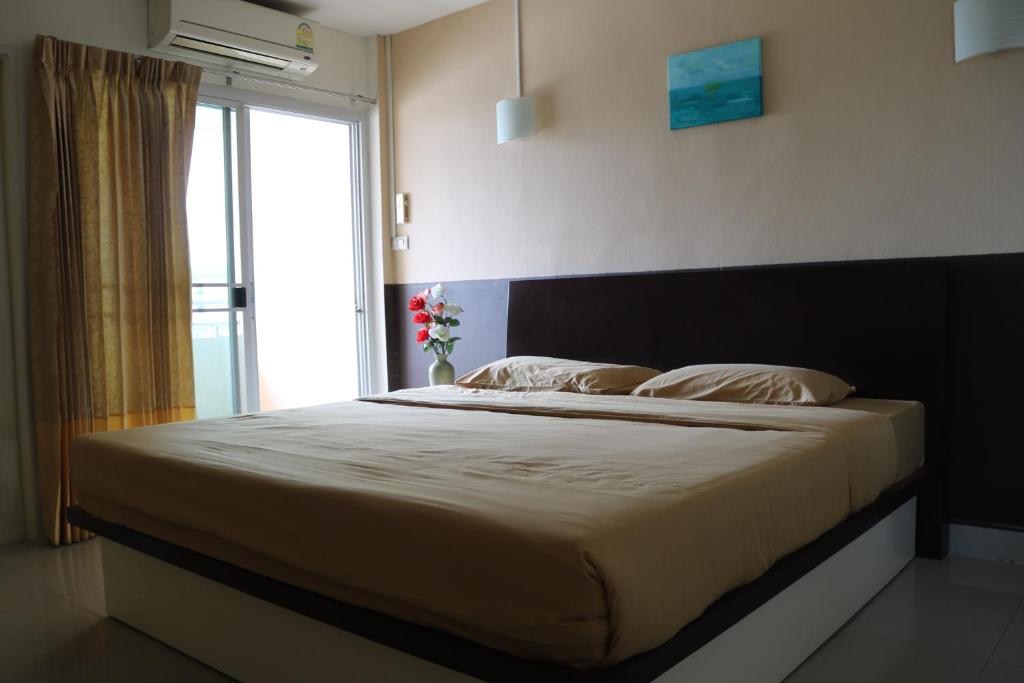 a bedroom with a large bed with a window at Ladapan Mansion in Nonthaburi