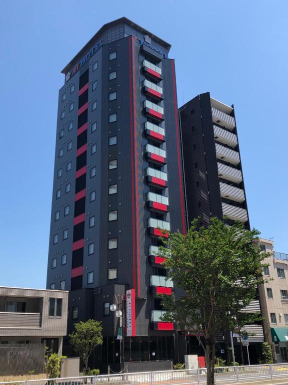 a tall black building with red and white windows at Ai Hotel Keikyu Kamata in Tokyo