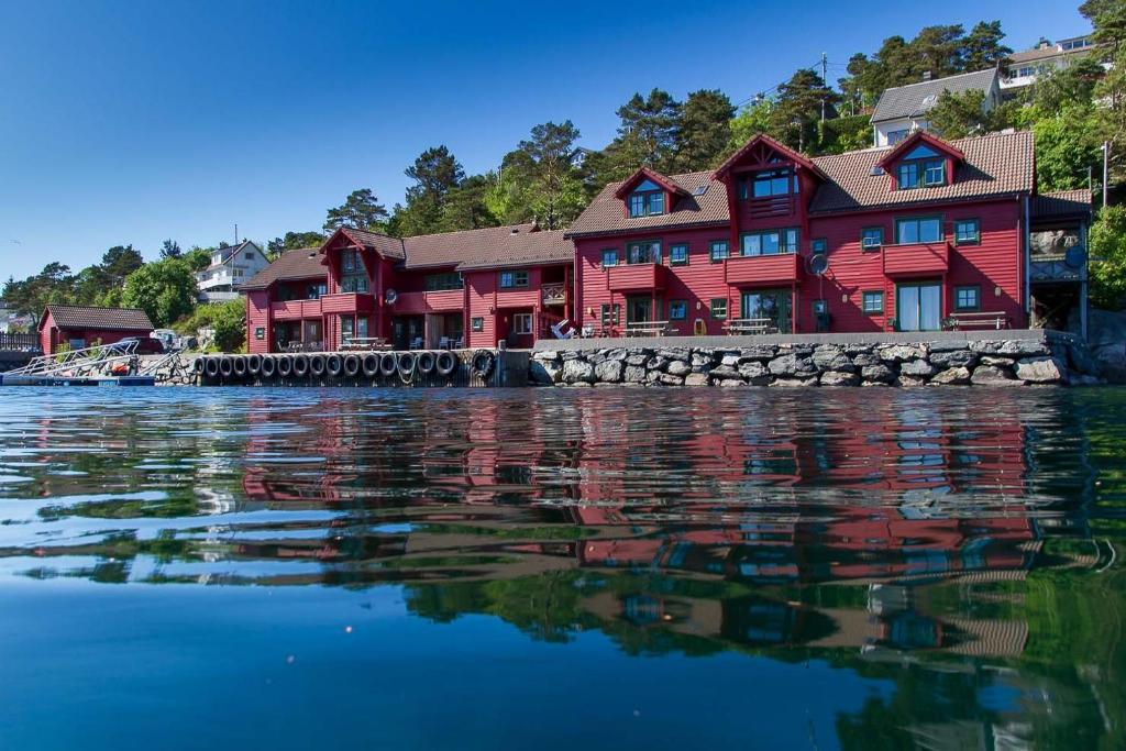 a row of red houses on the water at Florø Rorbu in Florø