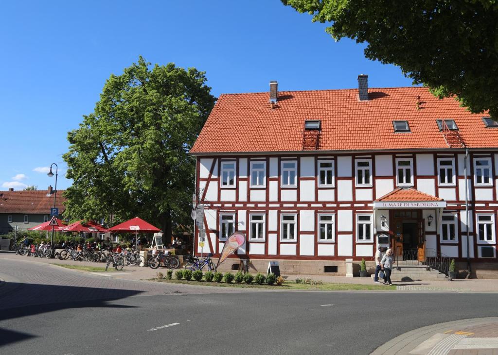 a large red and white building on the side of a street at Landgasthof-Hotel Zur Linde in Großenlüder