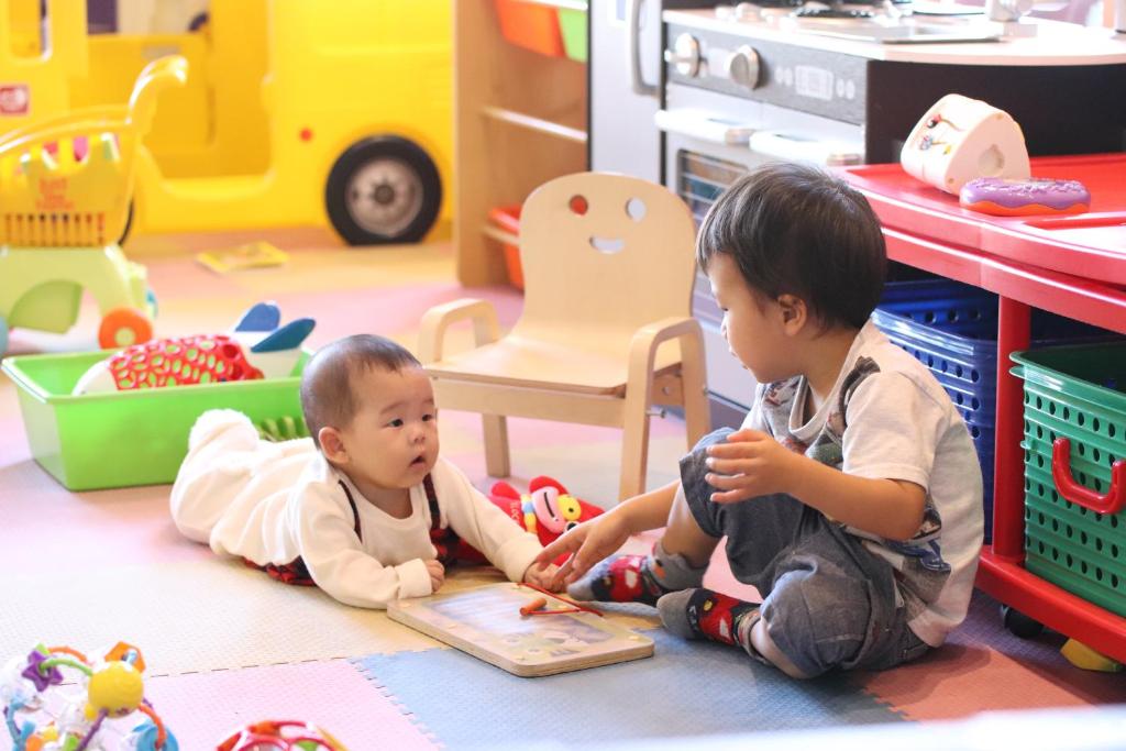 two babies sitting on the floor in a toy store at Hotel Ocean (Kokusai-Dori) in Naha