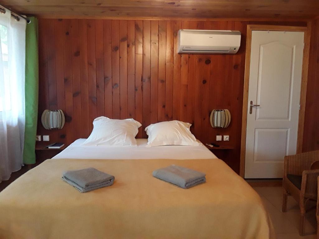 a bedroom with a bed with two towels on it at Les Hibiscus de la Rivière in Saint-Louis