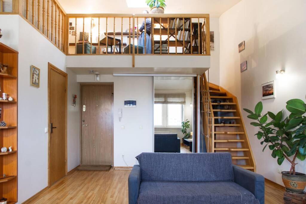 sala de estar con sofá azul y escalera en Penthouse Apartment with Great Panoramic City View, en Vilna