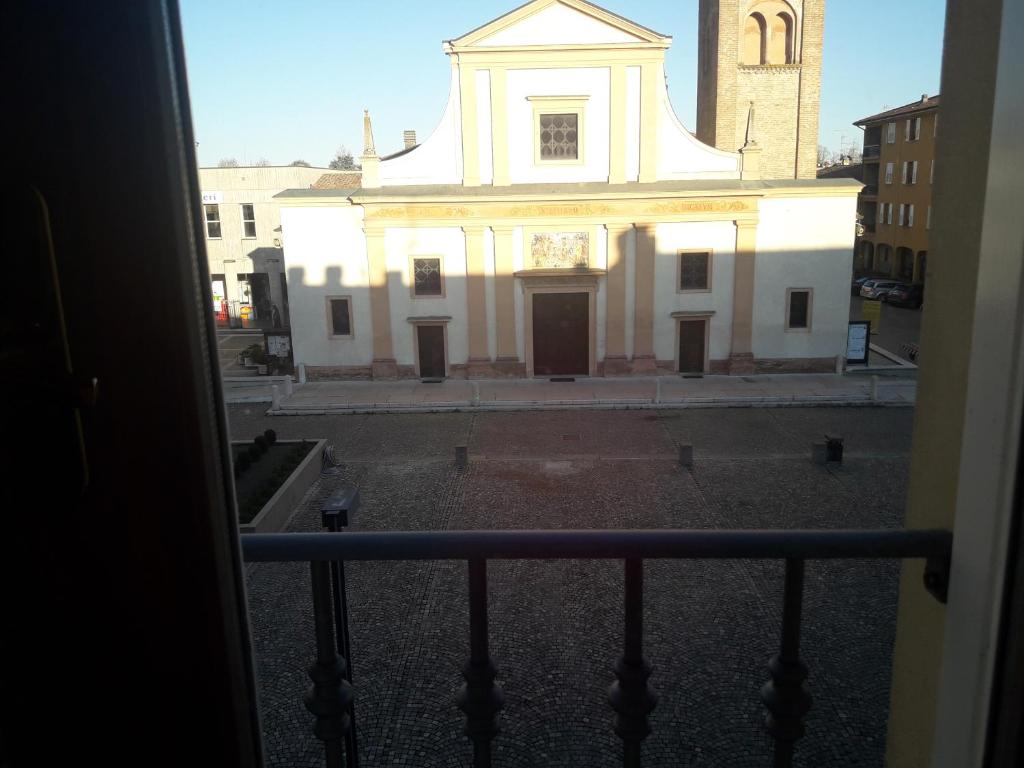 - une vue sur une église blanche depuis une fenêtre dans l'établissement Appartamento in centro a Poviglio (Re), à Poviglio