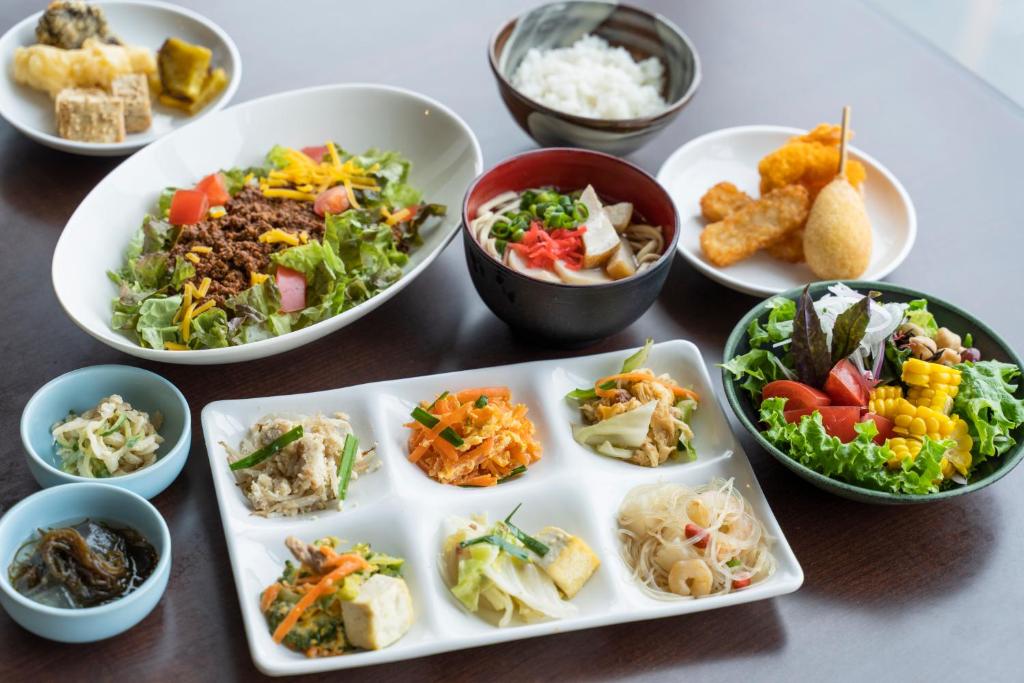 a table with plates of food and bowls of food at Hotel Ocean (Kokusai-Dori) in Naha