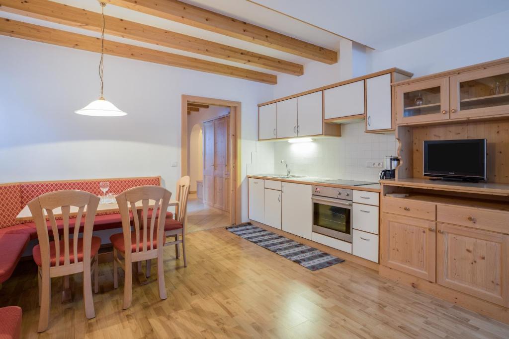 cocina con mesa y sillas y comedor en Wieserhof - Apartment Benjamin, en Valles