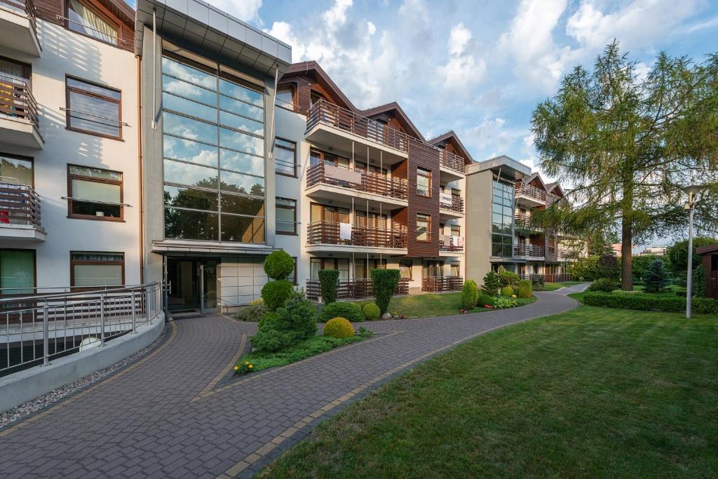 an apartment building with a walkway in front of it at Apartamenty Apartinfo Jasny Brzeg in Władysławowo